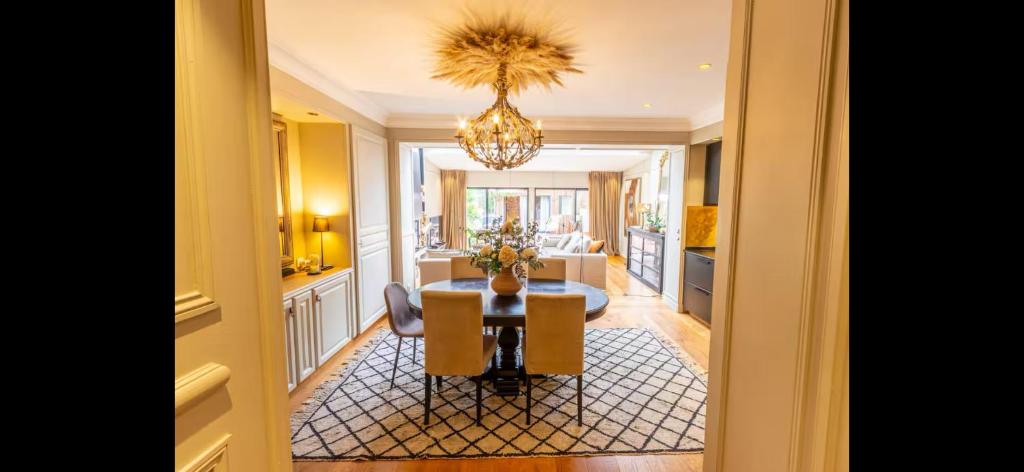 une salle à manger avec une table et un lustre dans l'établissement Maison de laura, à Bordeaux