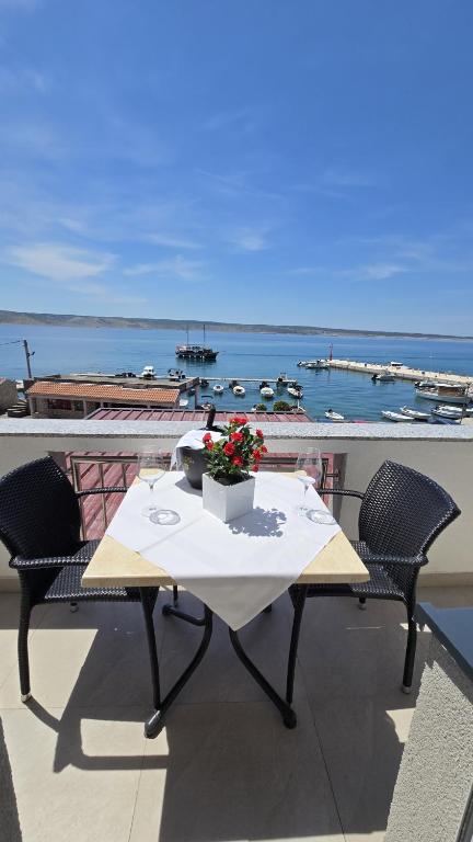 a table on a balcony with a view of the ocean at Aparthotel Tota in Starigrad