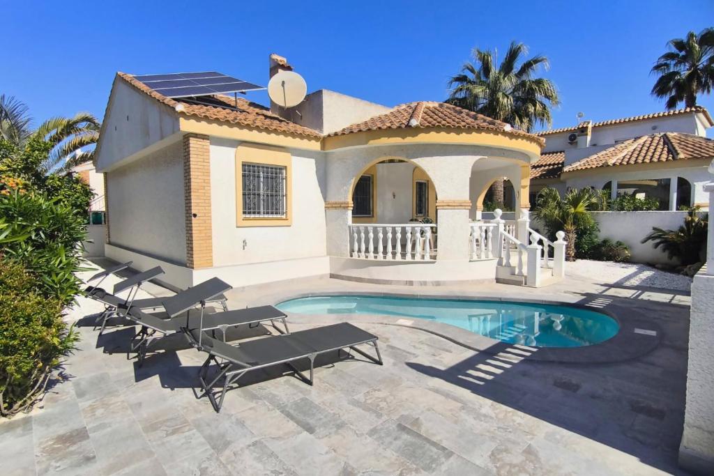 a villa with a swimming pool in front of a house at Casa Limonero by Rental Hero in Los Alcázares