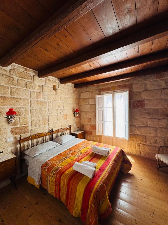 a bedroom with a large bed in a stone wall at Casa Vacanze Moonlight in Polignano a Mare