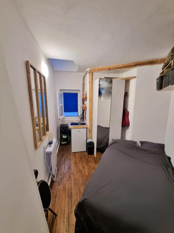 une chambre avec un lit, un bureau et un miroir dans l'établissement Studio Montmartre!, à Paris