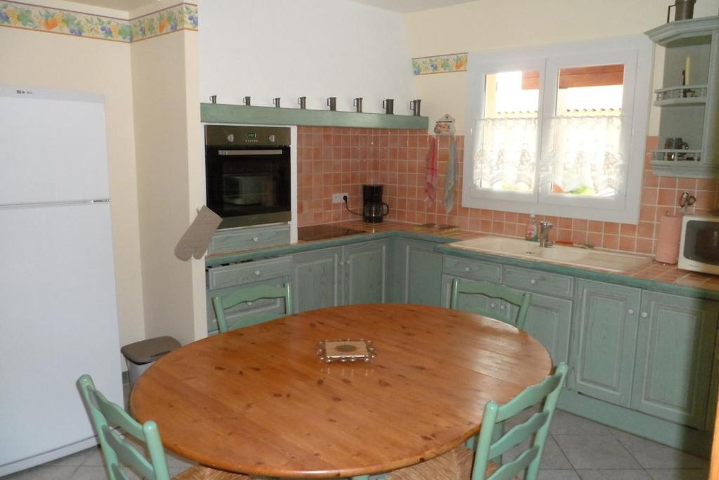 - une cuisine avec une table en bois dans l'établissement Gîte 8 Personnes Piscine Privée Aude Occitanie Sud Corbières, à Fabrezan