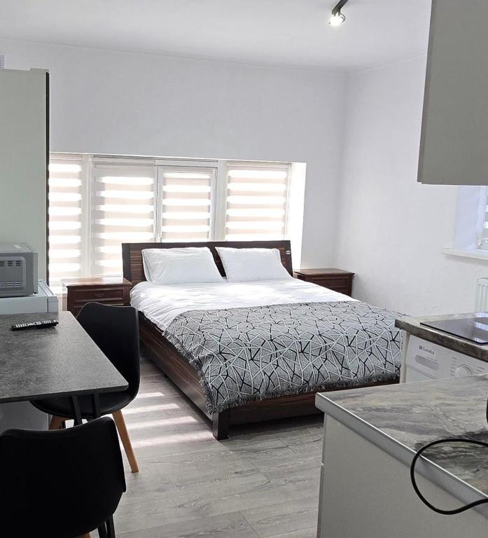 a bedroom with a bed and a kitchen with a desk at Small House ApartHotel in Chişinău