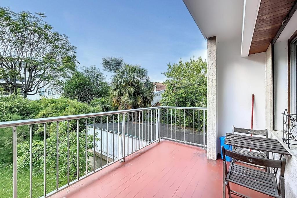 un balcon avec deux chaises et une vue sur l'eau dans l'établissement Cosy apartment near Roland-Garros, à Boulogne-Billancourt