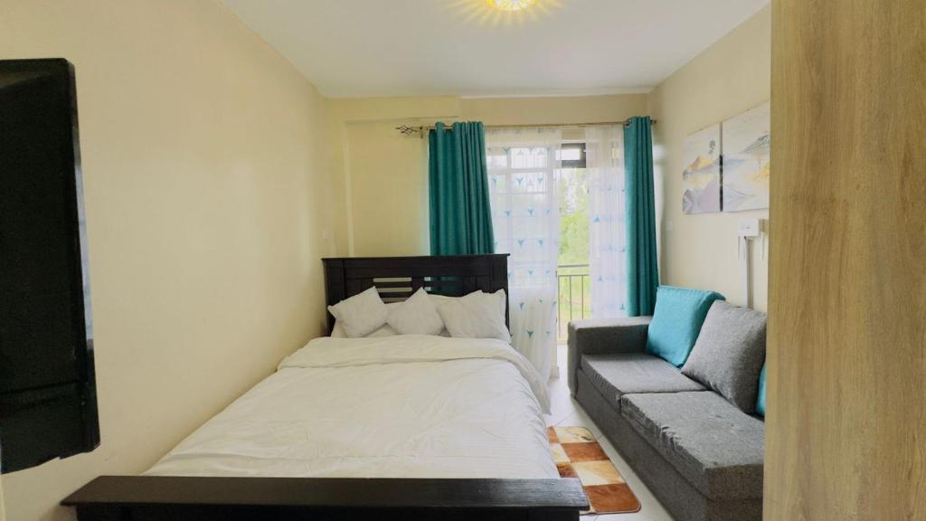 a small bedroom with a bed and a couch at Studio apartment Westlands Kitisuru in Nairobi