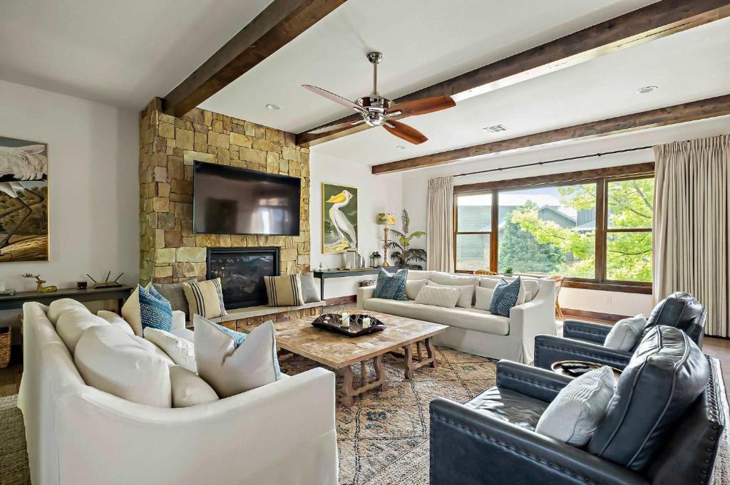 a living room with white furniture and a stone fireplace at Lake Travis Luxe Villa - 4BR, Pickleball & BBQ in Edgewater Beach