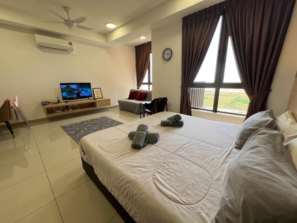 a bedroom with a large bed and a tv at Luxury & Lovely studio with waterpark in town in Melaka