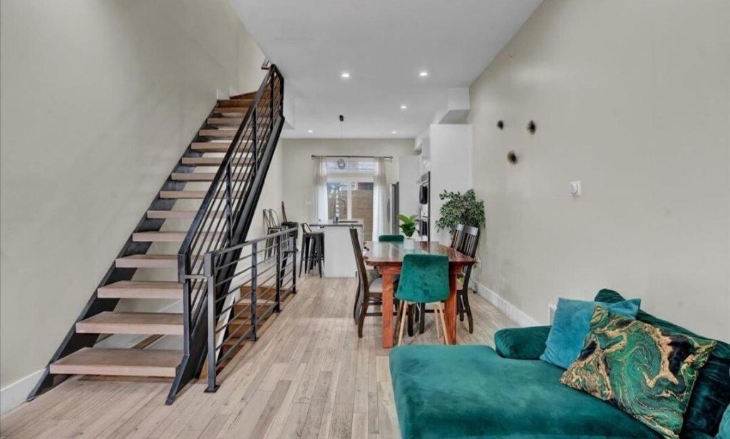 a living room with a staircase and a green couch at Emerald Jacuzzi Loft in Philadelphia