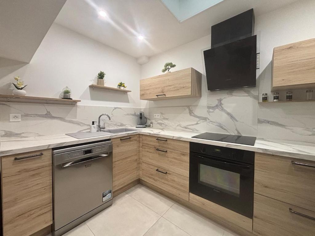 a kitchen with a sink and a stove top oven at Chez Cricri, modern accommodation in Bizanet