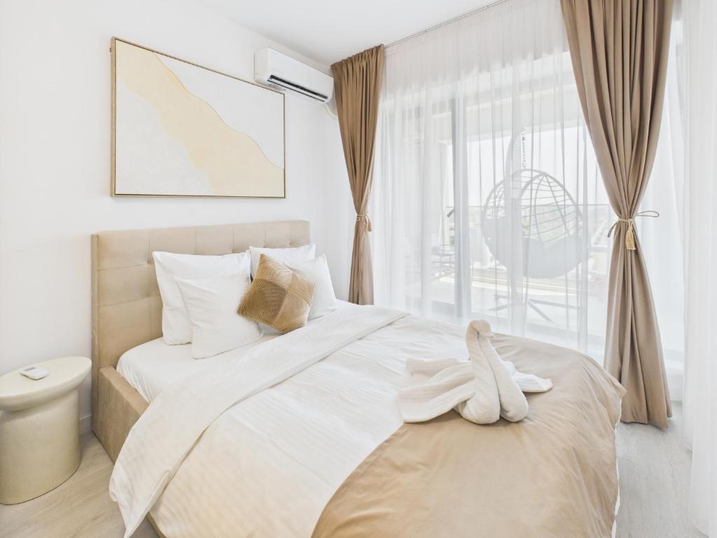 a bedroom with a bed with white sheets and a window at Lujerului Studio in Bucharest