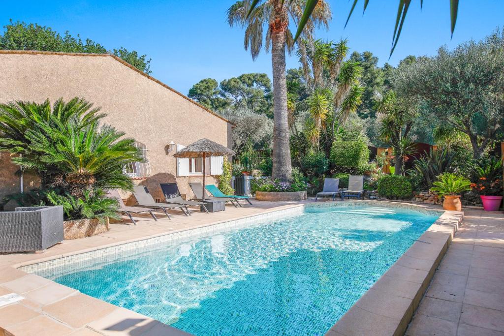 une piscine avec des chaises et une maison dans l'établissement LE MAS CECYLAE, à Carqueiranne