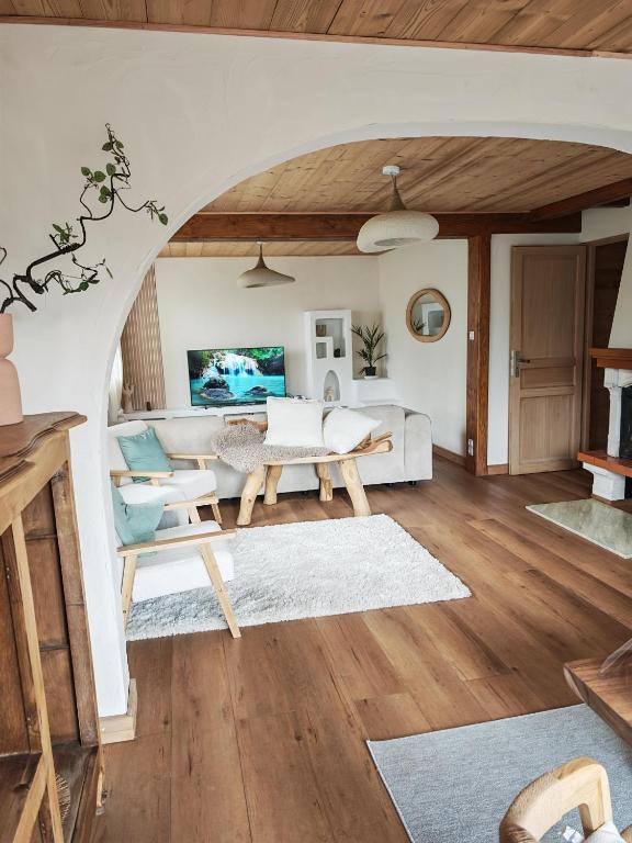 un salon avec un canapé et une table dans l'établissement Chalet Toscane avec bain nordique, à La Bresse