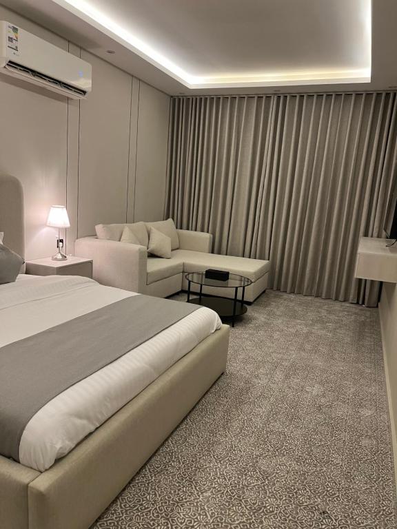 a hotel room with a bed and a couch at استديو فاخر حي الندى in Riyadh