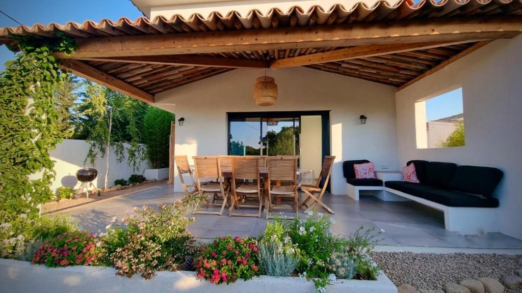 un patio avec une table et des chaises sous une pergola dans l'établissement Villa Maestro Maria Charme Confort et Accueil Chaleureux à 5 min de la plage, à Lecci