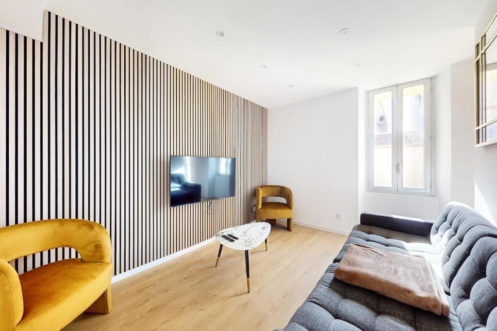 un salon avec un canapé et une télévision sur un mur dans l'établissement App refait neuf 3P Clim proche plage palais festival, à Cannes