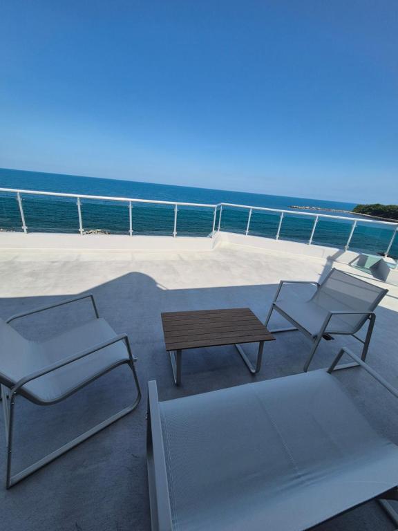 a patio with a table and chairs and the ocean at Elite Family Hotel in Kiten