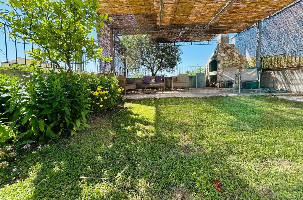 a patio with benches and flowers in a yard at Holiday Home Sea & River Pearl in Komin