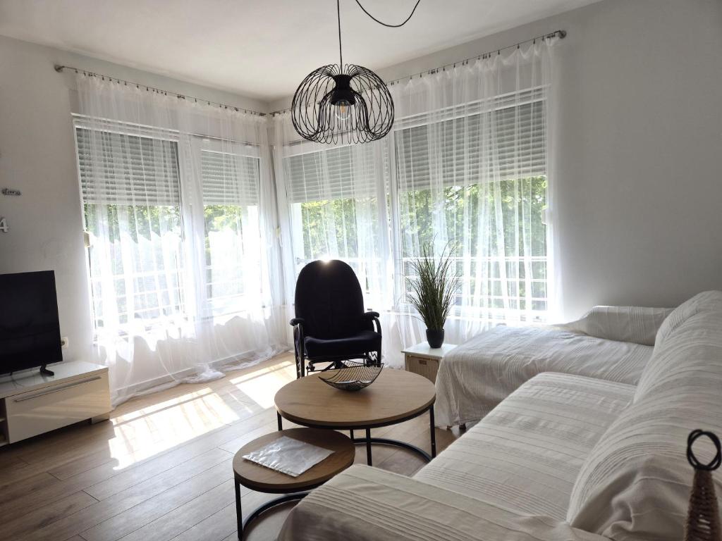 sypialnia z łóżkiem, krzesłem i telewizorem w obiekcie Deluxe Apartments Goya w mieście Zadar