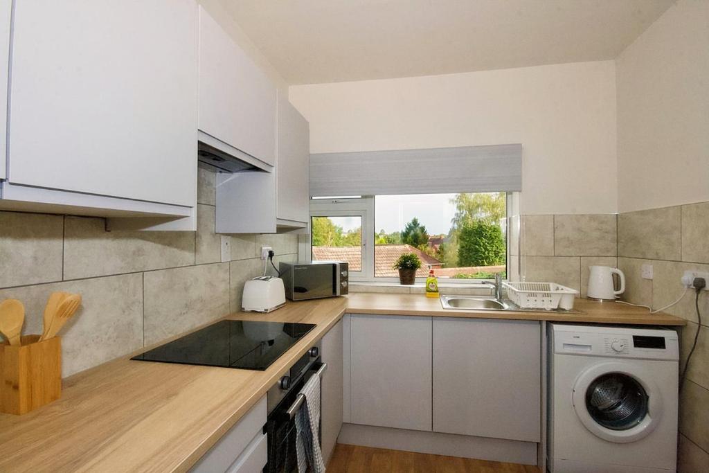 a kitchen with a sink and a washing machine at 33 Beautiful 2 bed apt Tamworth Private Parking in Fazeley