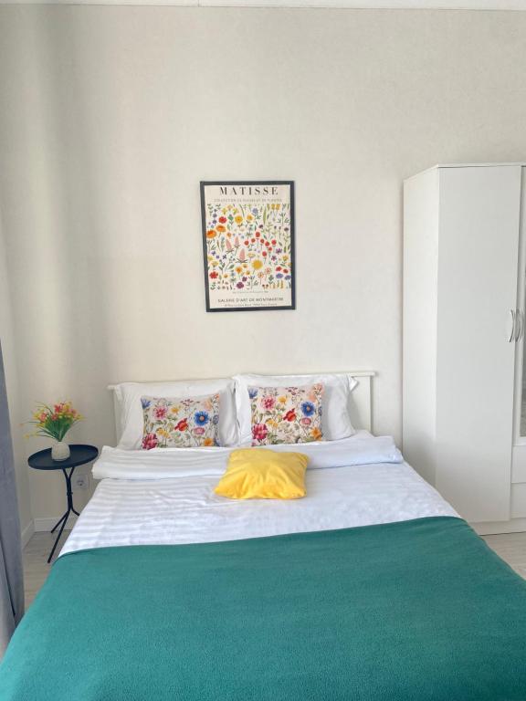 a bedroom with a white bed with a yellow pillow at Greenline in Taldykolʼ