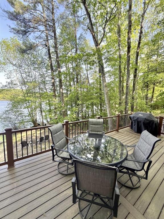 a patio with a glass table and chairs on a deck at JOYFULL CAMP LIMIT 10 cottage in Naples