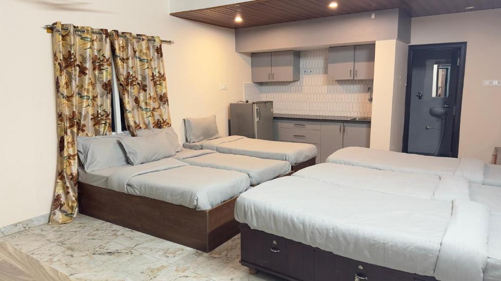 a room with two beds and a kitchen at City home-SGH in Mysore