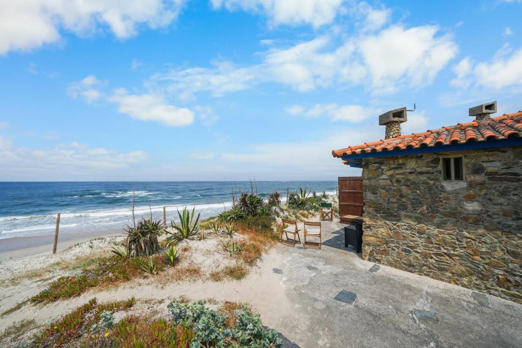 a stone house on the beach near the ocean at Sea Hut Apulia in Apúlia