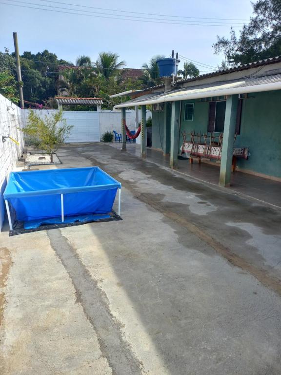 a blue tub sitting outside of a house at Ar condicionado ! Pousada familiar natureza Rustic in Ilha Comprida