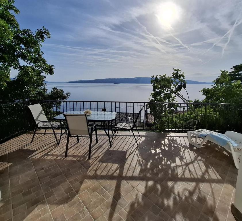 a patio with a table and chairs and a view of the water at Apartment Loza Senj in Senj