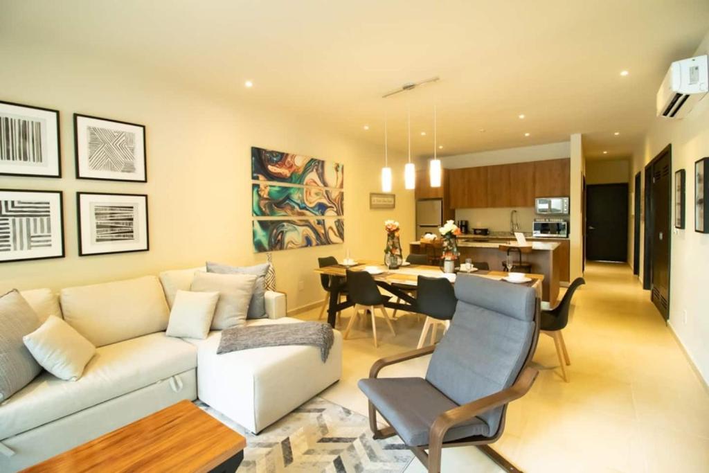 a living room with a couch and a dining room at RayoDeSol Condo10min to Beach,Gym,Pool,WIFI 200MB in Playa del Carmen
