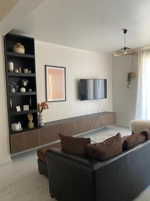 un salon avec un canapé et une télévision à écran plat dans l'établissement Superbe T2 refait à neuf, tout équipé, très lumineux, au calme ! Parking privé - Ajaccio, à Ajaccio