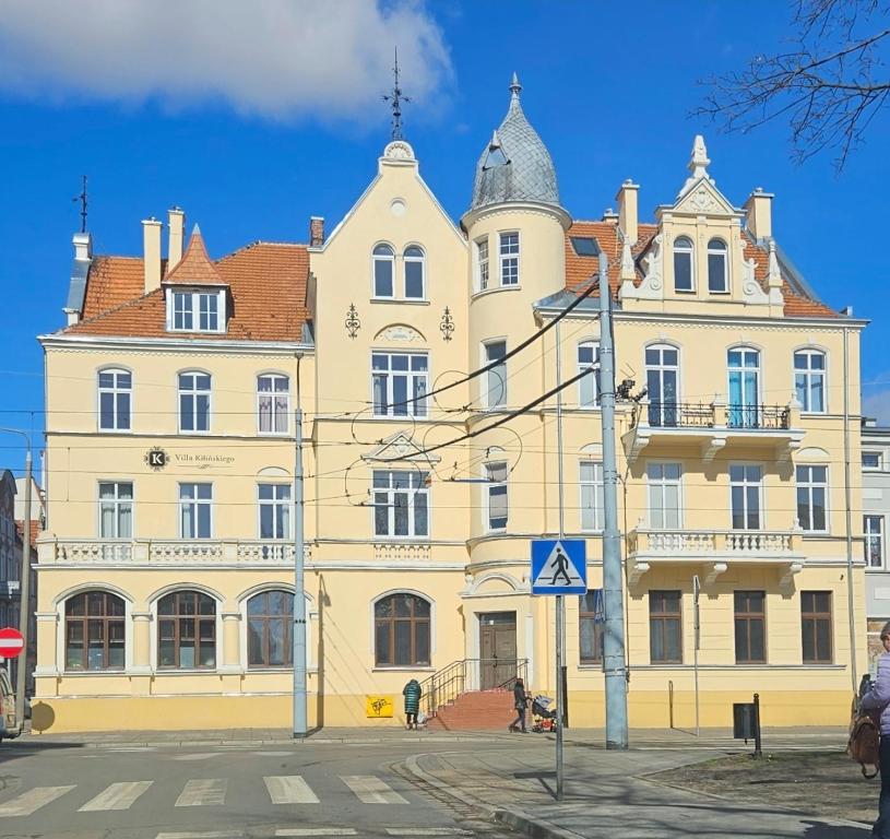 a large yellow building on the side of a street at Apartament Willa Kilińskiego in Grudziądz