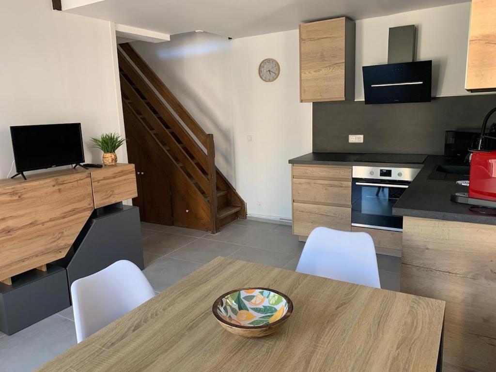 - une cuisine avec une table en bois et des chaises blanches dans l'établissement Maison Argelès sur mer - 400 m de la plage, à Argelès-sur-Mer