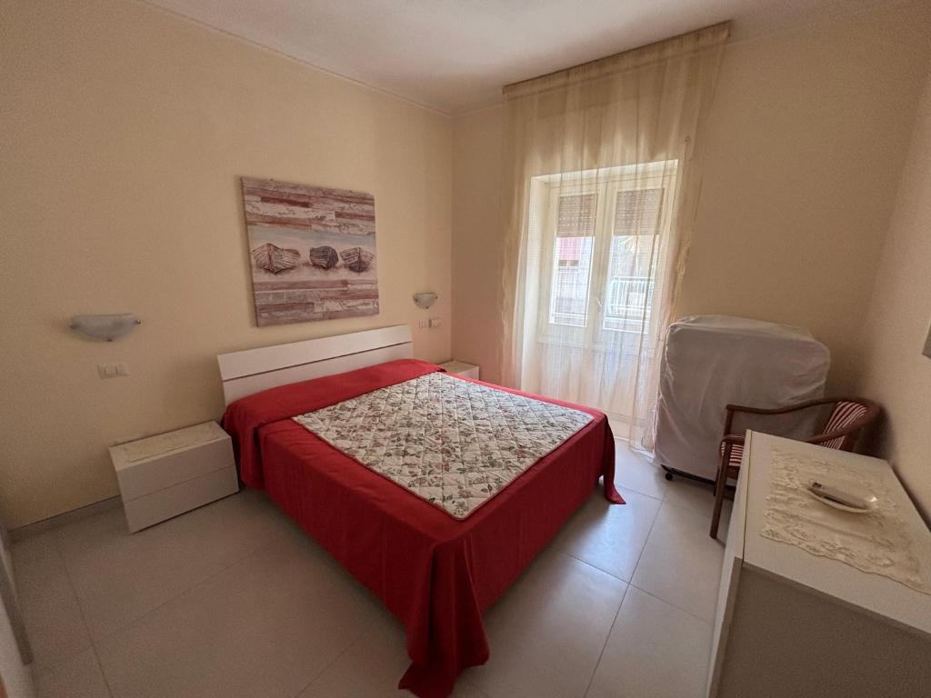 een slaapkamer met een rood bed en een raam bij Casa Vacanza Gallipoli 1D in Gallipoli