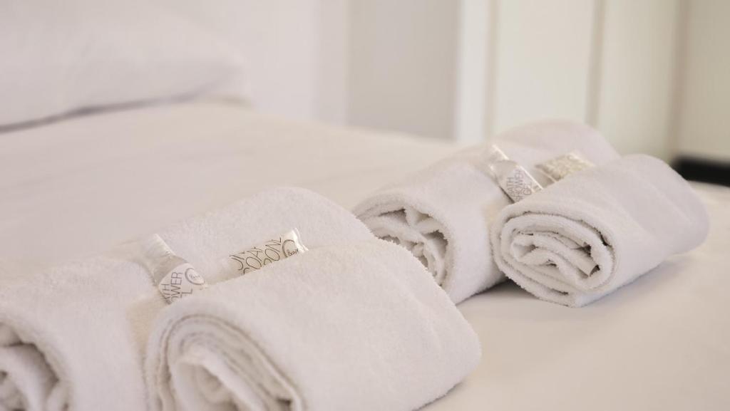 a pile of white towels sitting on a bed at Al Ludomar, Cozy Flat and Free Park in Rapallo
