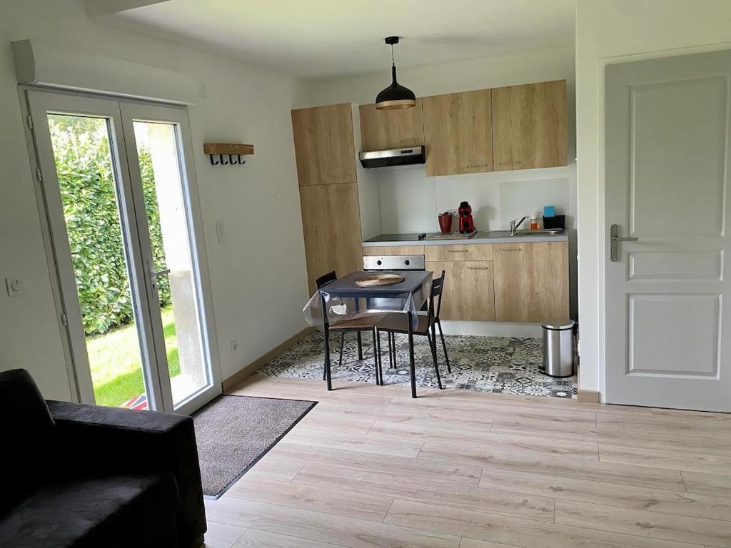 a kitchen with a table and chairs in a room at Charming studio between lakes and mountains in La Biolle