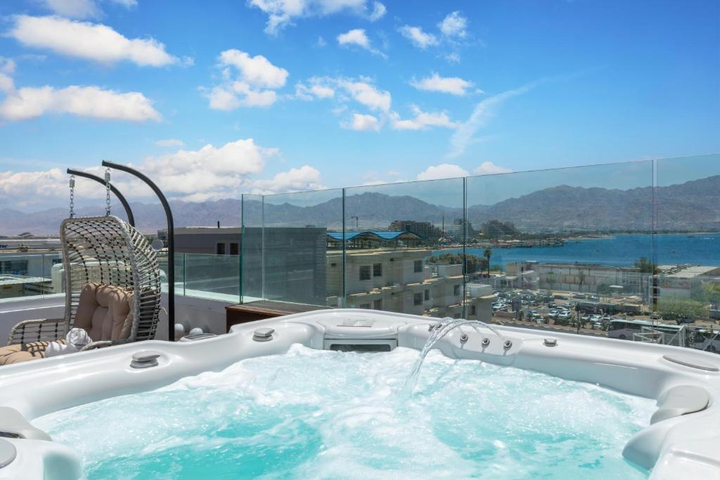 a hot tub on a balcony with a view of the water at Luxury Suites With Balcony And Jacuzzi At Sea Side By Rently in Eilat