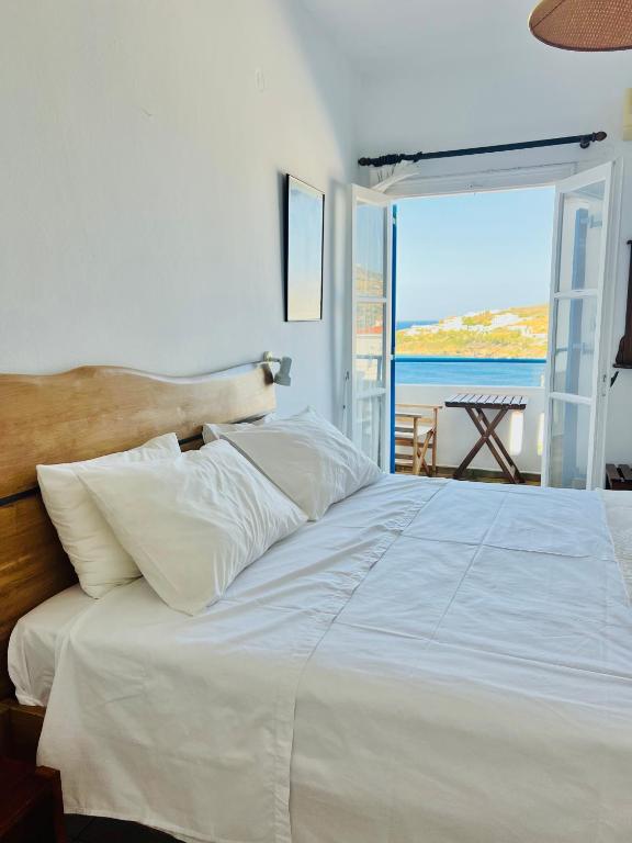 a large white bed with a view of the ocean at White & Blue in Batsi