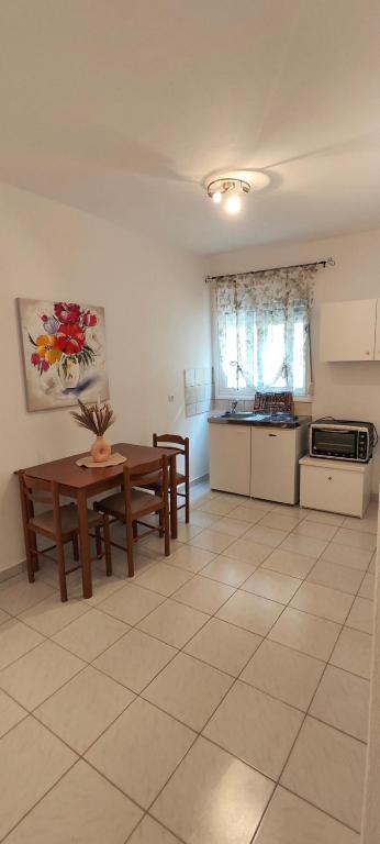 a living room with a table and a kitchen at KANALI HOLIDAYS APARTMENT 2 in Kanali
