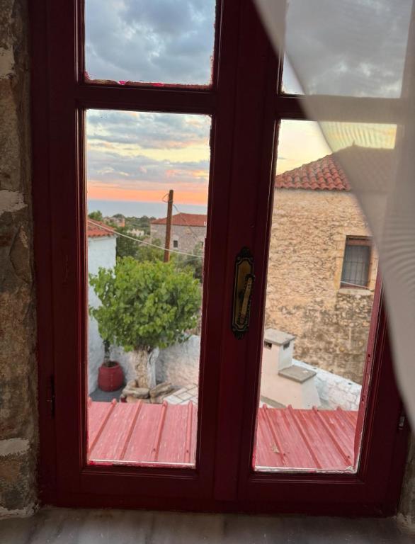 a window with a view of a building at Lithos Areopoli Traditional House in Areopoli