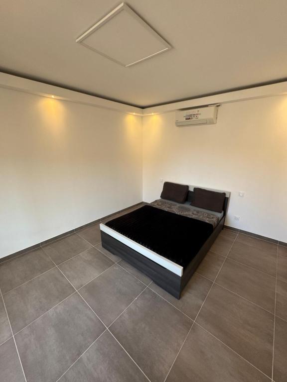 une chambre avec un lit dans le coin d'une pièce dans l'établissement 3 pièces Mandelieu, à Mandelieu-la-Napoule