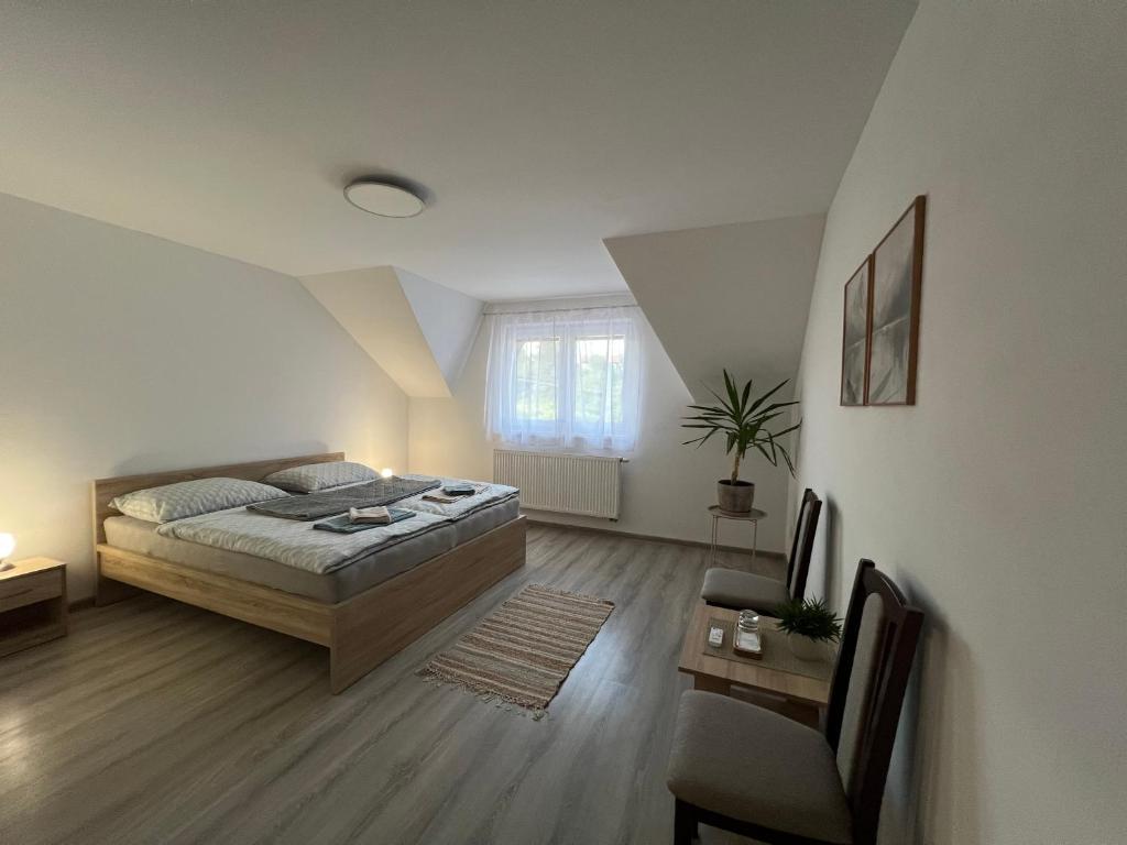 a bedroom with a bed and a chair in it at Ubytovanie PLATAN in Bartošovce