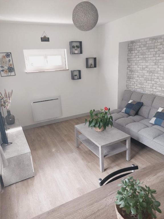 un salon avec un canapé et une table dans l'établissement Petite maison au calme, à Le Mesnil-Germain