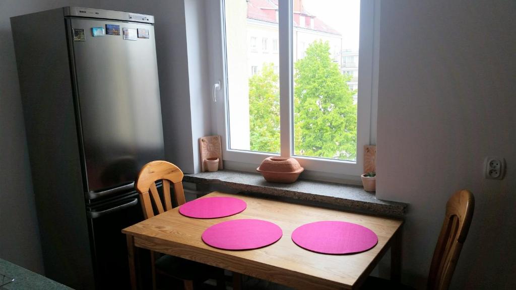 uma cozinha com uma mesa de madeira com placas cor-de-rosa em Apartament Dworcowa em Kolobrzeg