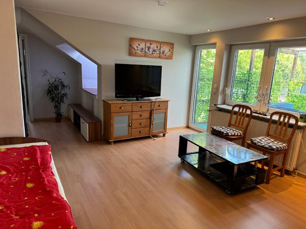a living room with a television and a table at Gasthaus Wicky in Hemdingen
