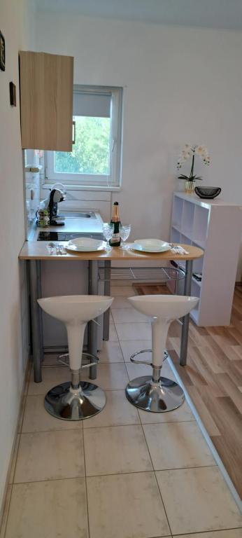 a kitchen with two bar stools and a counter top at Studio apartman I&R in Ciovo