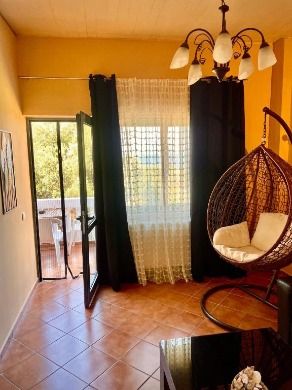 a living room with a hanging chair and a window at Caramel Cloud in Mytilene