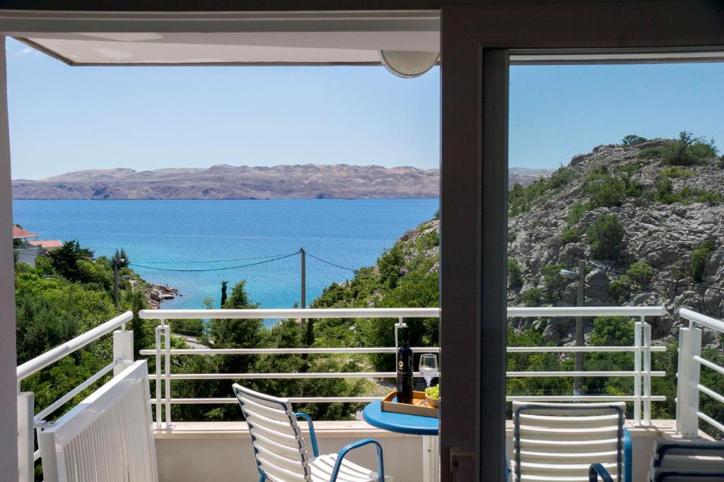 ein Balkon mit Stühlen und Blick auf das Meer in der Unterkunft Apartments Sunny in Karlobag