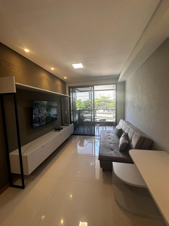 a living room with a couch and a flat screen tv at SKY Concept 306 in Maceió