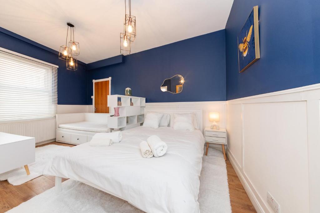 a bedroom with blue walls and a large white bed at Free Parking 2 Beds Studio Flat close to River Thames in Reading